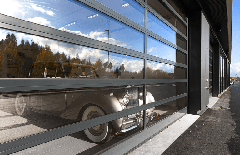Bentley bil bak en gjennomsiktig industriport